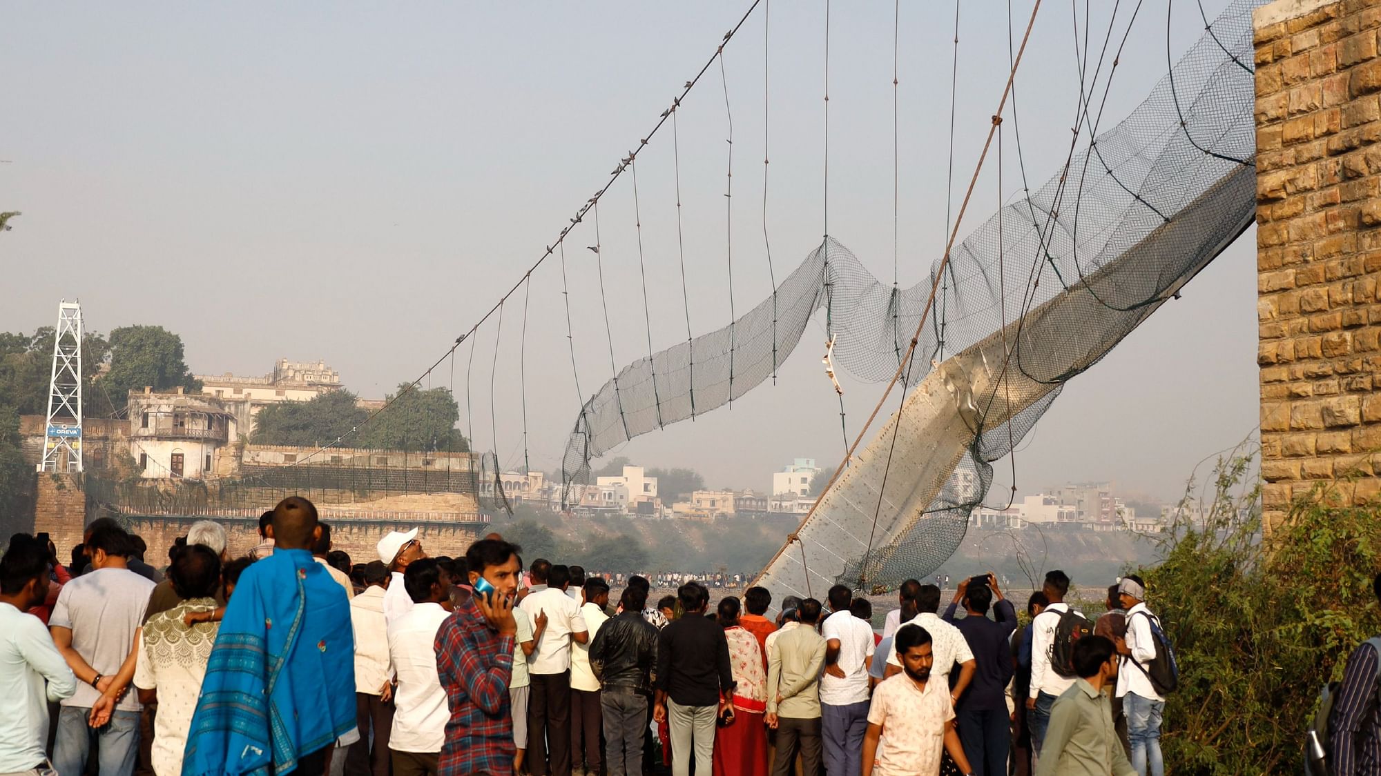 <div class="paragraphs"><p>Morbi: People gather at the site during a rescue operation after the collapse of a suspension bridge over the Machchhu river, in Morbi district, Monday, Oct. 31, 2022.</p></div>