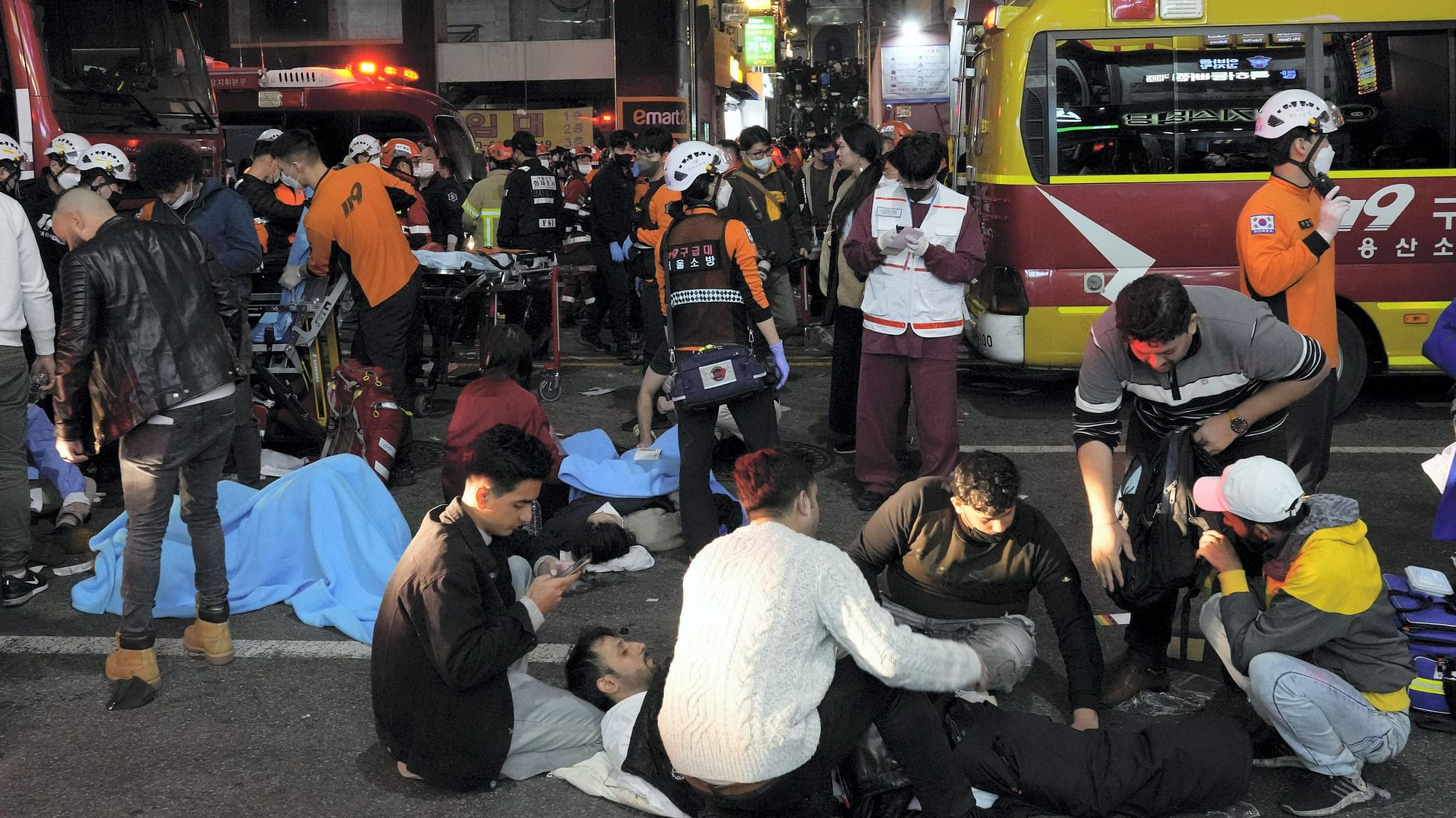 <div class="paragraphs"><p>Rescue workers and firefighters try to help survivors after a stampede killed over 150 in South Korea's Seoul on Saturday night, 30 October.&nbsp;</p></div>