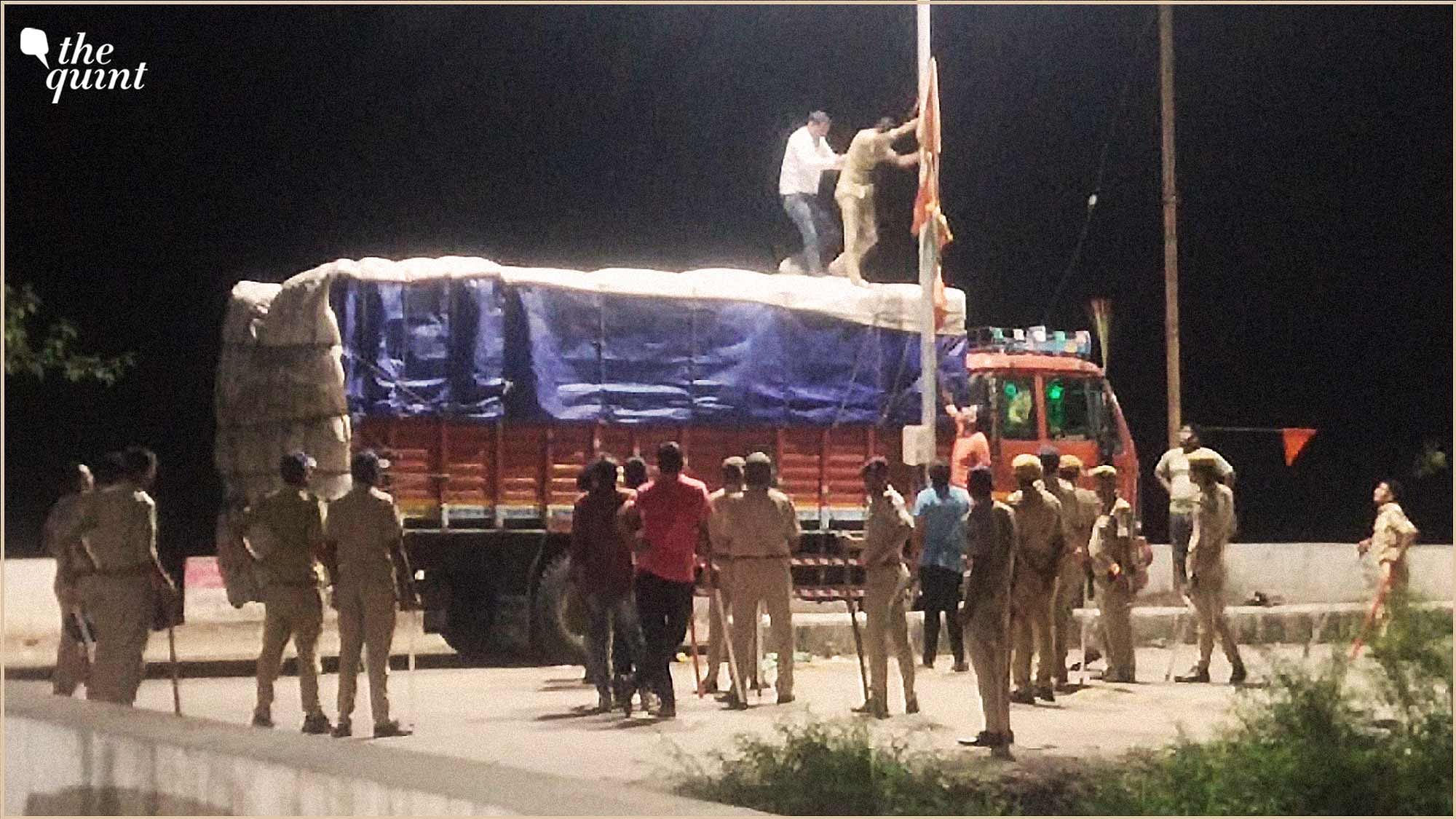 <div class="paragraphs"><p>Police officials take down a saffron flag hoisted at an electric pole in Savli, Gujarat.&nbsp;</p></div>