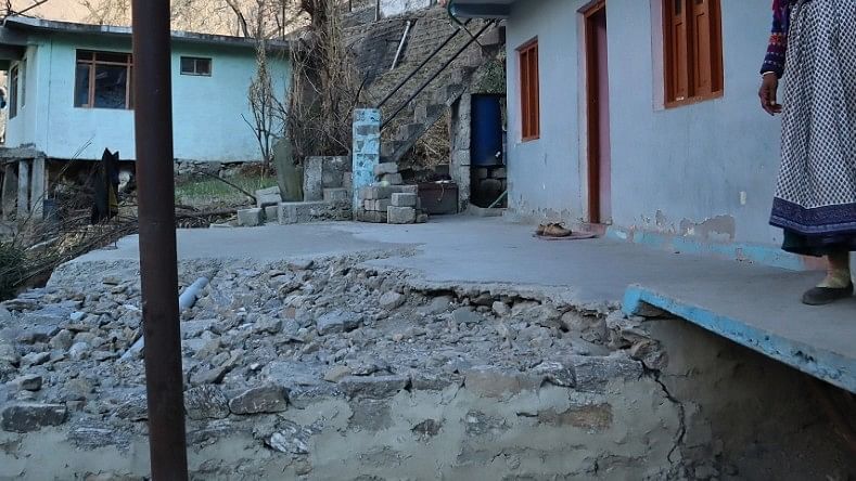 <div class="paragraphs"><p>A woman at Joshimath shows her broken courtyard. Joshimath witnessed a rapid subsidence event in early January where houses began cracking on a large scale and hundreds of people had to be evacuated. </p></div>