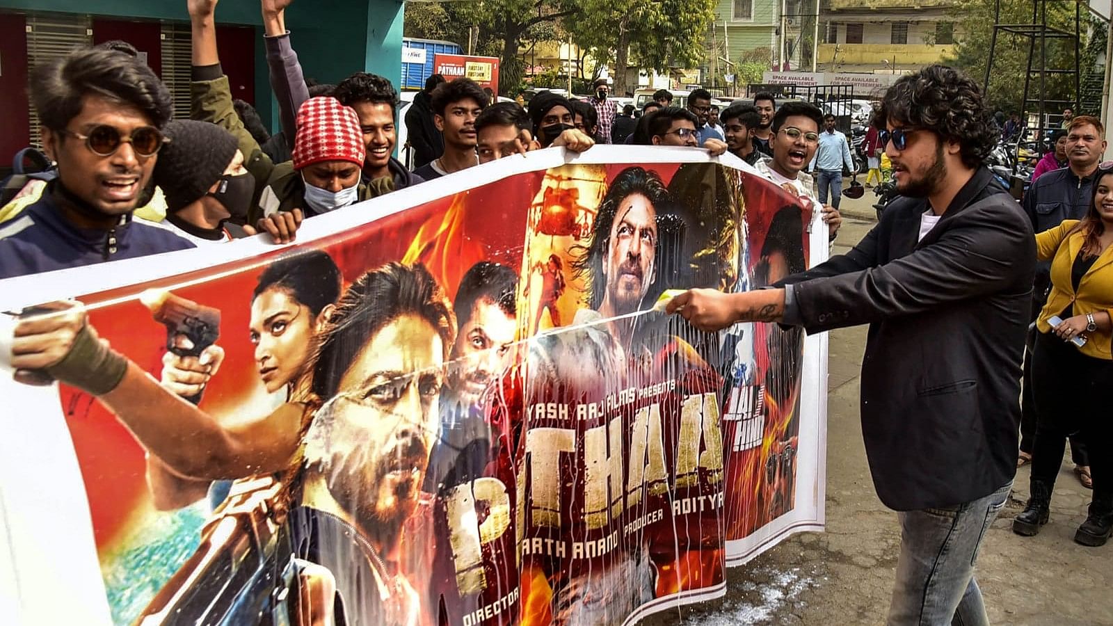 <div class="paragraphs"><p>Guwahati: Shah Rukh Khan fans pour milk on a poster of <em>Pathaan</em> movie during the first show of the film.</p></div>