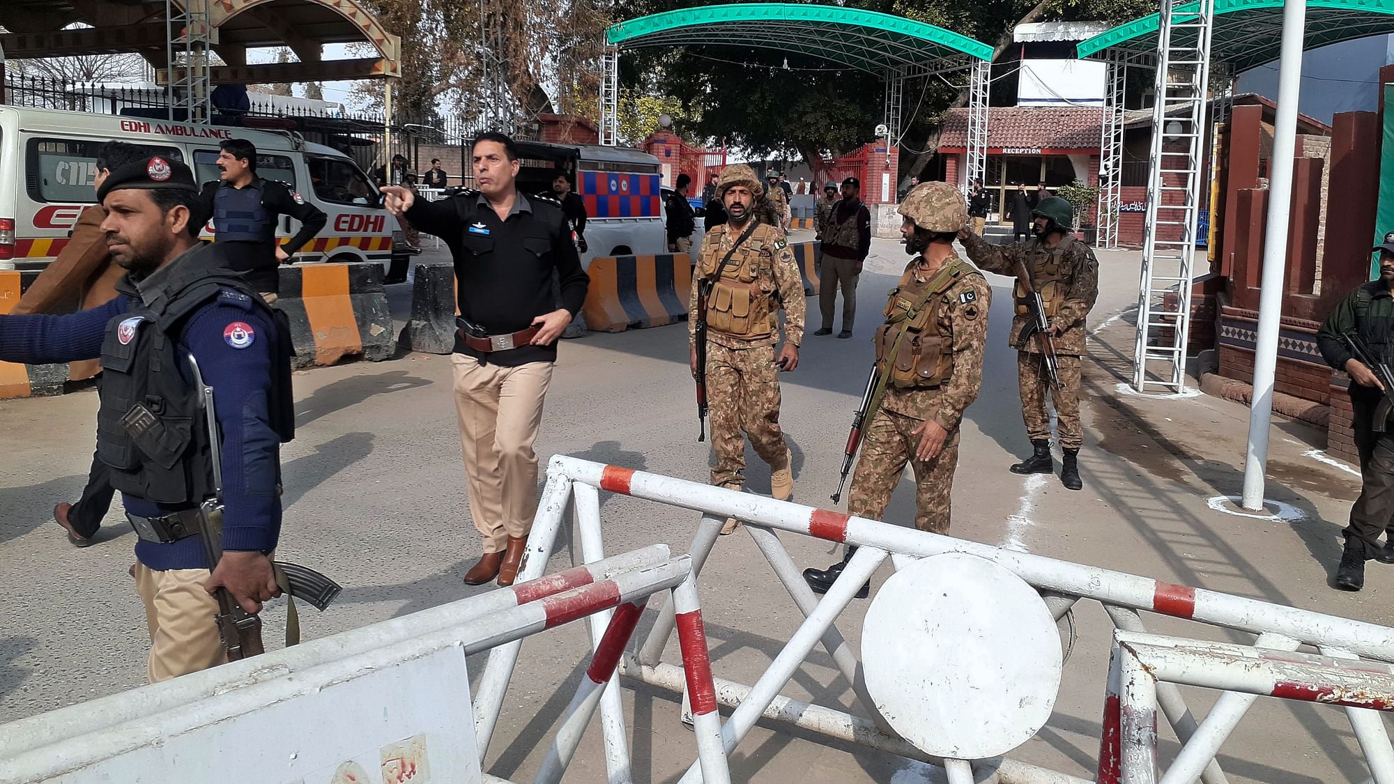 <div class="paragraphs"><p>Army soldiers and police officers clear the way for ambulances rushing toward a bomb explosion site, at the main entry gate of police offices, in Peshawar, Pakistan, Monday, 30 January.</p></div>