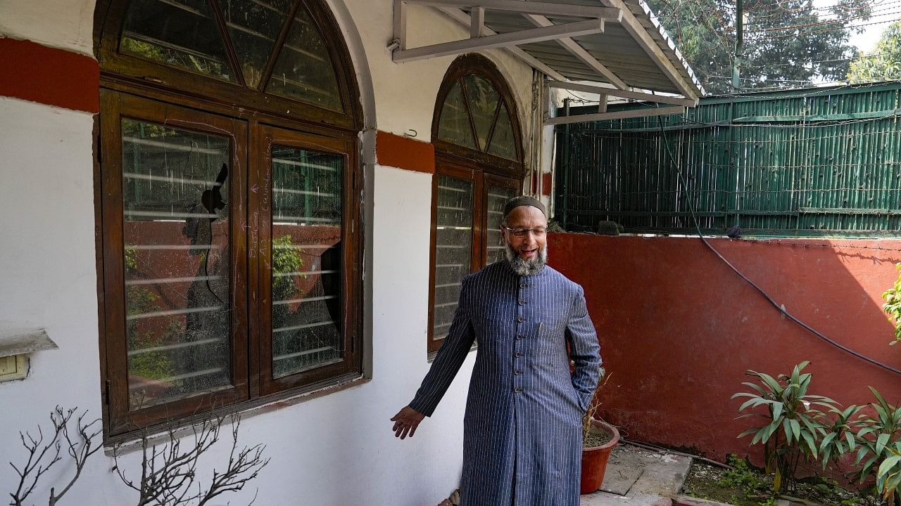 <div class="paragraphs"><p>AIMIM chief and MP Asaduddin Owaisi stands next to the damaged windowpanes at his residence in New Delhi on Monday, 20 February.</p></div>