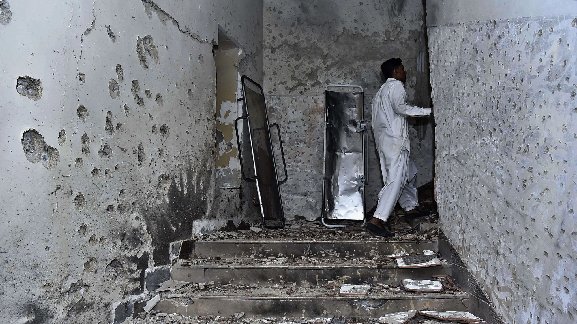 <div class="paragraphs"><p>A plainclothes police officer stands beside the bullet-riddled walls after security forces conduct an operation against attackers at a police headquarters, in Karachi, Pakistan, on Friday, 17 February.</p></div>