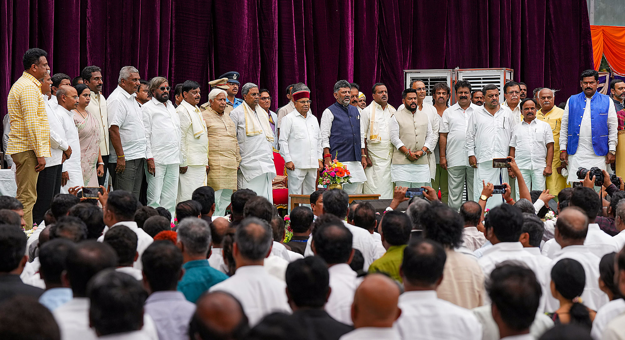 <div class="paragraphs"><p>Karnataka Governor Thaawarchand Gehlot, Karnataka Chief Minister Siddaramaiah, and Deputy Chief Minister DK Shivakumar with newly-inducted cabinet ministers during the swearing-in ceremony at Raj Bhavan in Bengaluru on Saturday, 27 May.</p></div>