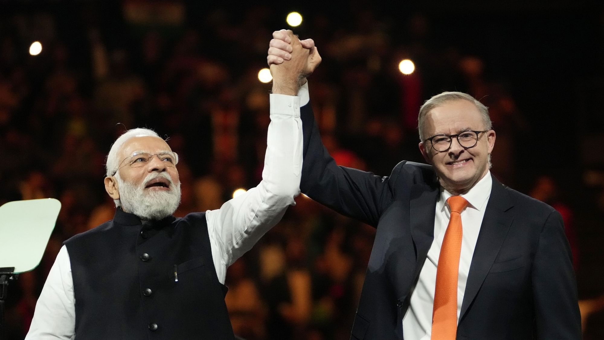 <div class="paragraphs"><p>Indian Prime Minister Narendra Modi, left, holds hands with his Australian counterpart Anthony Albanese during an Indian community event at Qudos Bank Arena in Sydney, Australia on Monday, 23 May.</p></div>