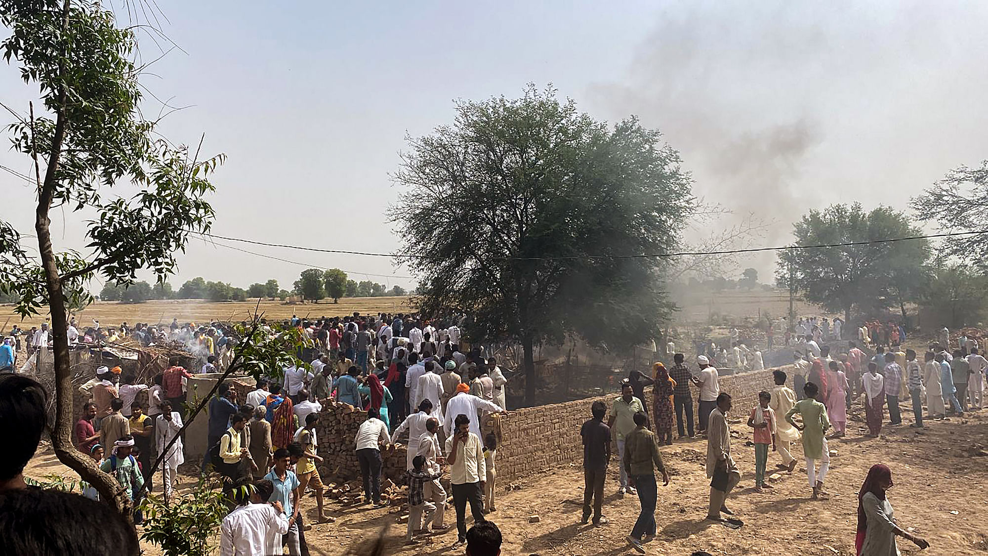 <div class="paragraphs"><p>Locals gather after a MiG-21 fighter aircraft of the Indian Air Force (IAF) crashed in the Hanumangarh district of Rajasthan on Monday, 8 May.</p></div>