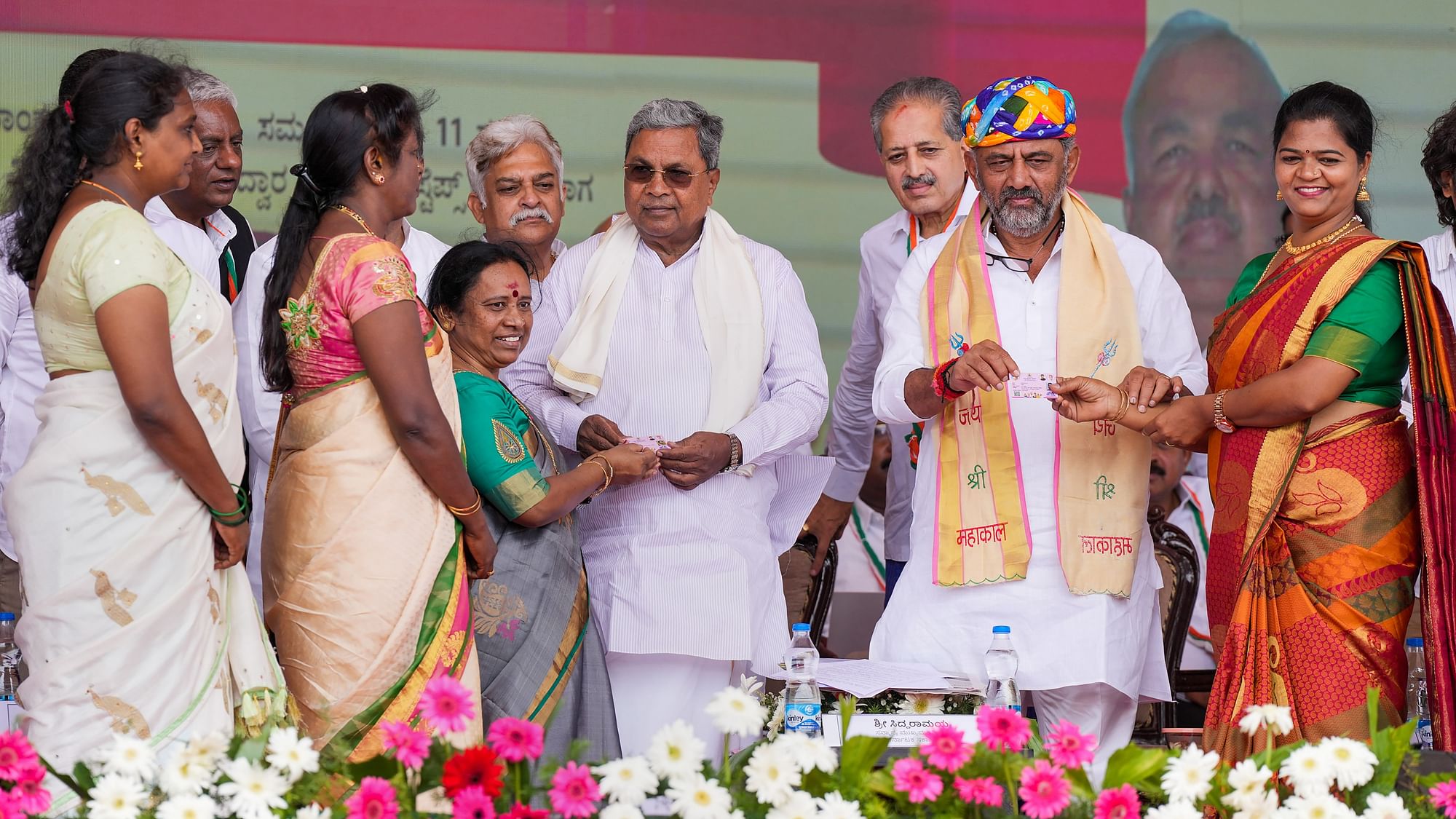 <div class="paragraphs"><p>Karnataka CM Siddaramaiah and Deputy CM DK Shivakumar distributing replicas of smart cards to women while flagging off the Shakti scheme in Bengaluru on Sunday, 11 June.&nbsp;</p></div>