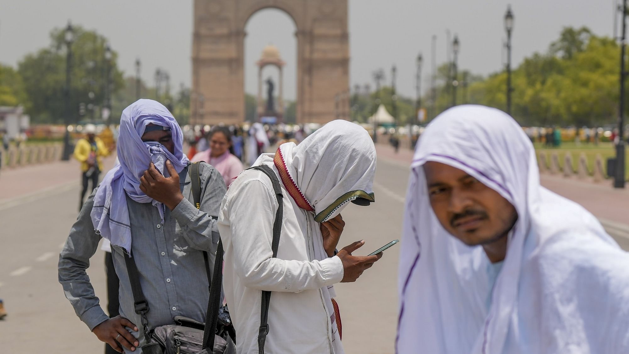 <div class="paragraphs"><p>Photographers cover themselves with scarves during a hot summer afternoon, at the India Gate, in New Delhi, on Saturday, 10 June.</p></div>