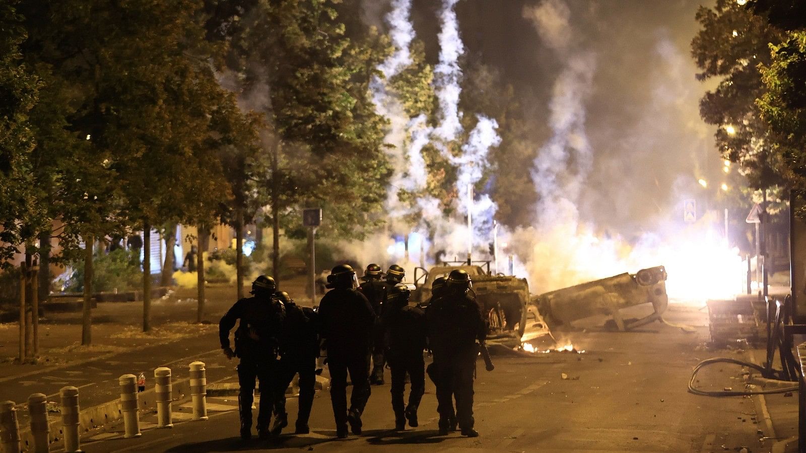 <div class="paragraphs"><p>Riot police officers patrol as smoke billows from burnt vehicles on the third night of protests sparked by the fatal police shooting of a 17-year-old driver in the Paris suburb of Nanterre, France, Friday, June 30, 2023. </p></div>