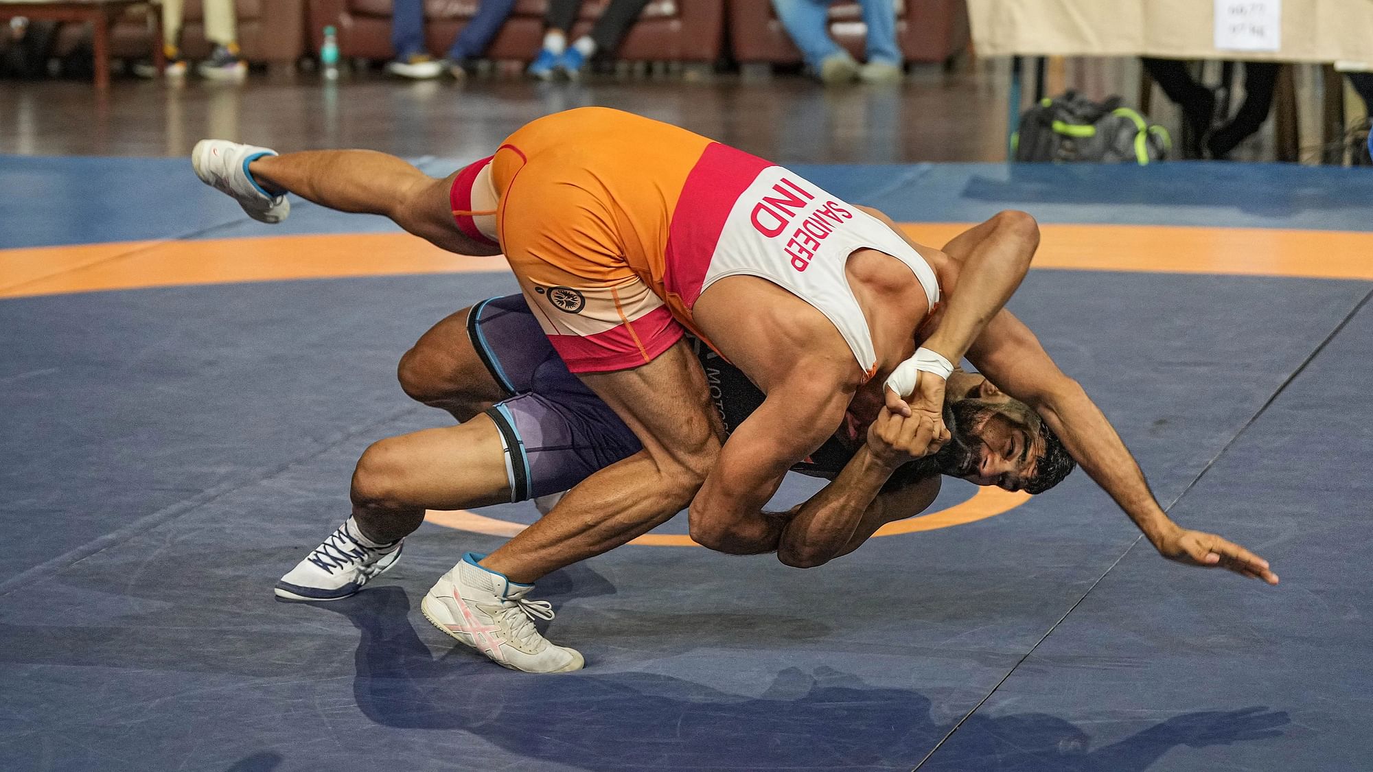 <div class="paragraphs"><p>Sandeep (in orange) of SSCB and Saurabh of Uttar Pradesh compete in the mens 60kg category event during the Asian Games 2023 wrestling trials, at Indra Gandhi Stadium in New Delhi on Saturday, 22 July.</p></div>