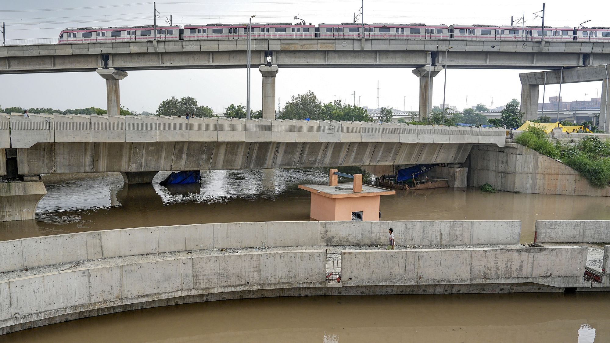 <div class="paragraphs"><p>A Delhi Metro train passes above the floodwaters of the swollen Yamuna river at Mayur Vihar in New Delhi on Wednesday, 12 July.</p></div>
