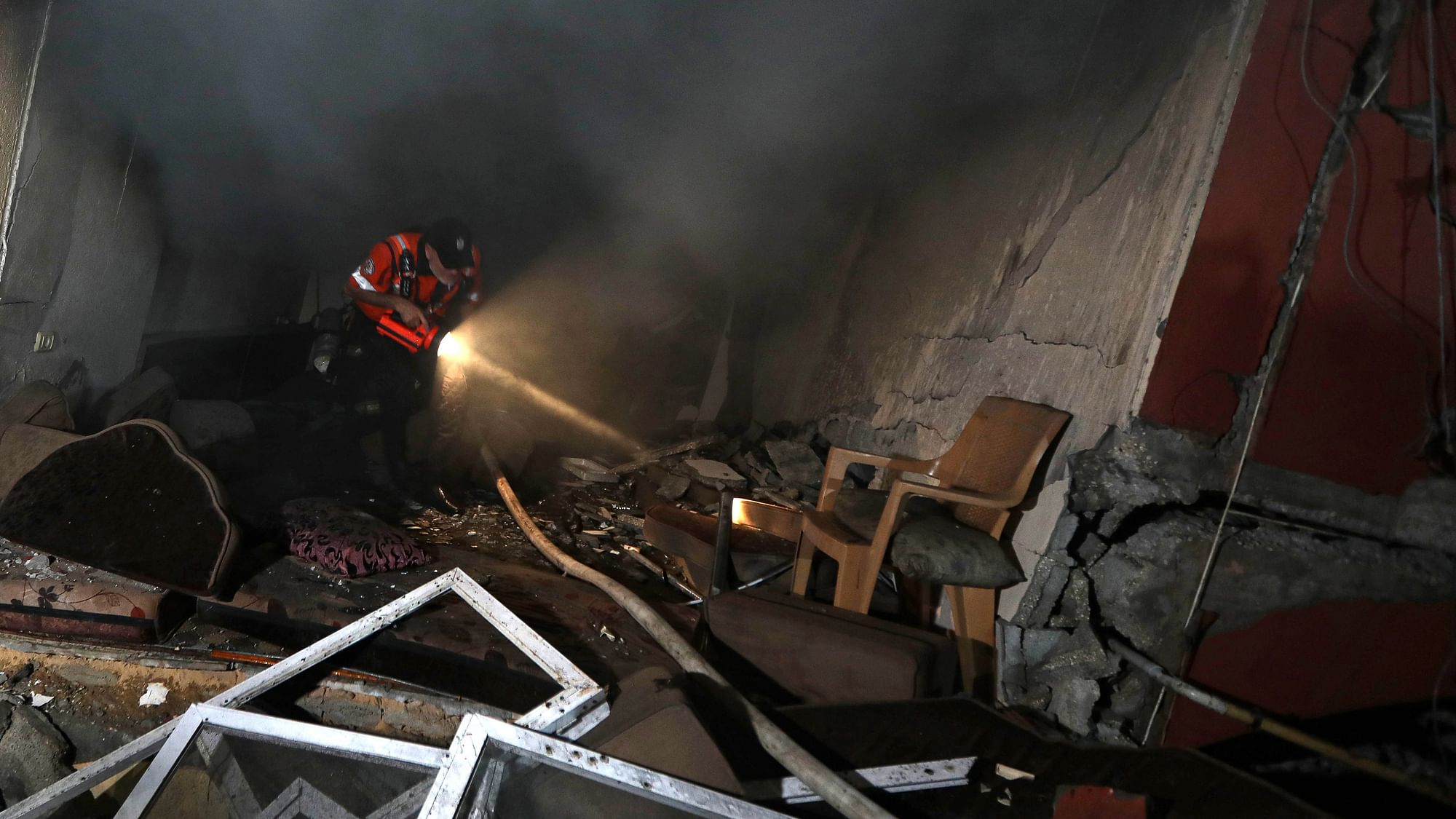 <div class="paragraphs"><p>Palestinian civil defense crew looks through a house that was hit by an Israeli airstrike in Khan Younis in the southern Gaza Strip on Sunday, 8 October.</p></div>