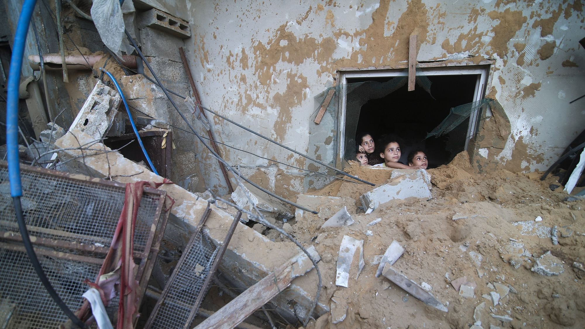 <div class="paragraphs"><p>Palestinian children look at the building of the Zanon family, destroyed in Israeli airstrikes in Rafah, Gaza Strip, Saturday, Oct. 14, 2023. </p></div>