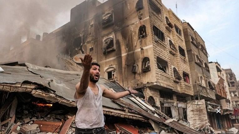 <div class="paragraphs"><p>A man reacts outside a burning collapsed building following Israeli bombardment in Gaza City. </p></div>
