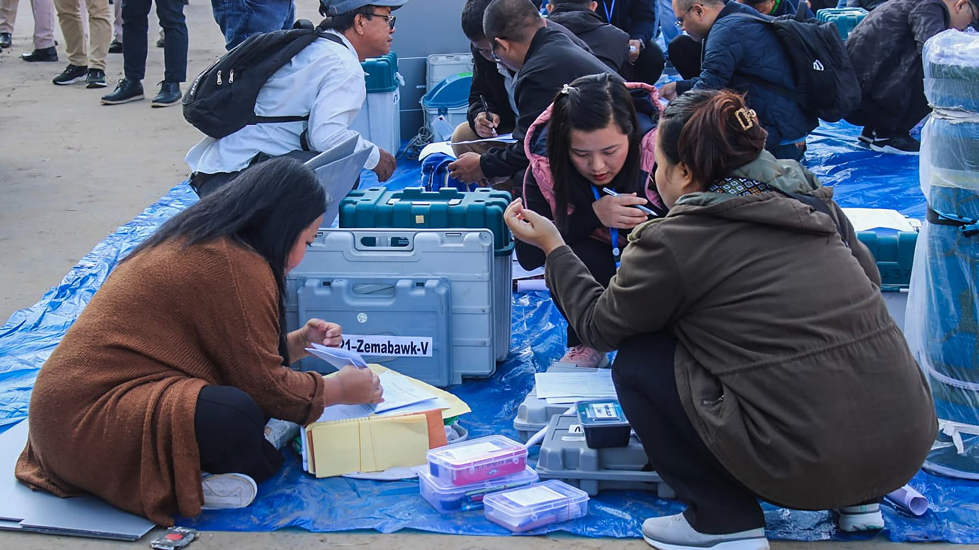 <div class="paragraphs"><p>Polling officials collect EVMs and other election material at a distribution centre ahead of voting for Mizoram Assembly elections.</p></div>