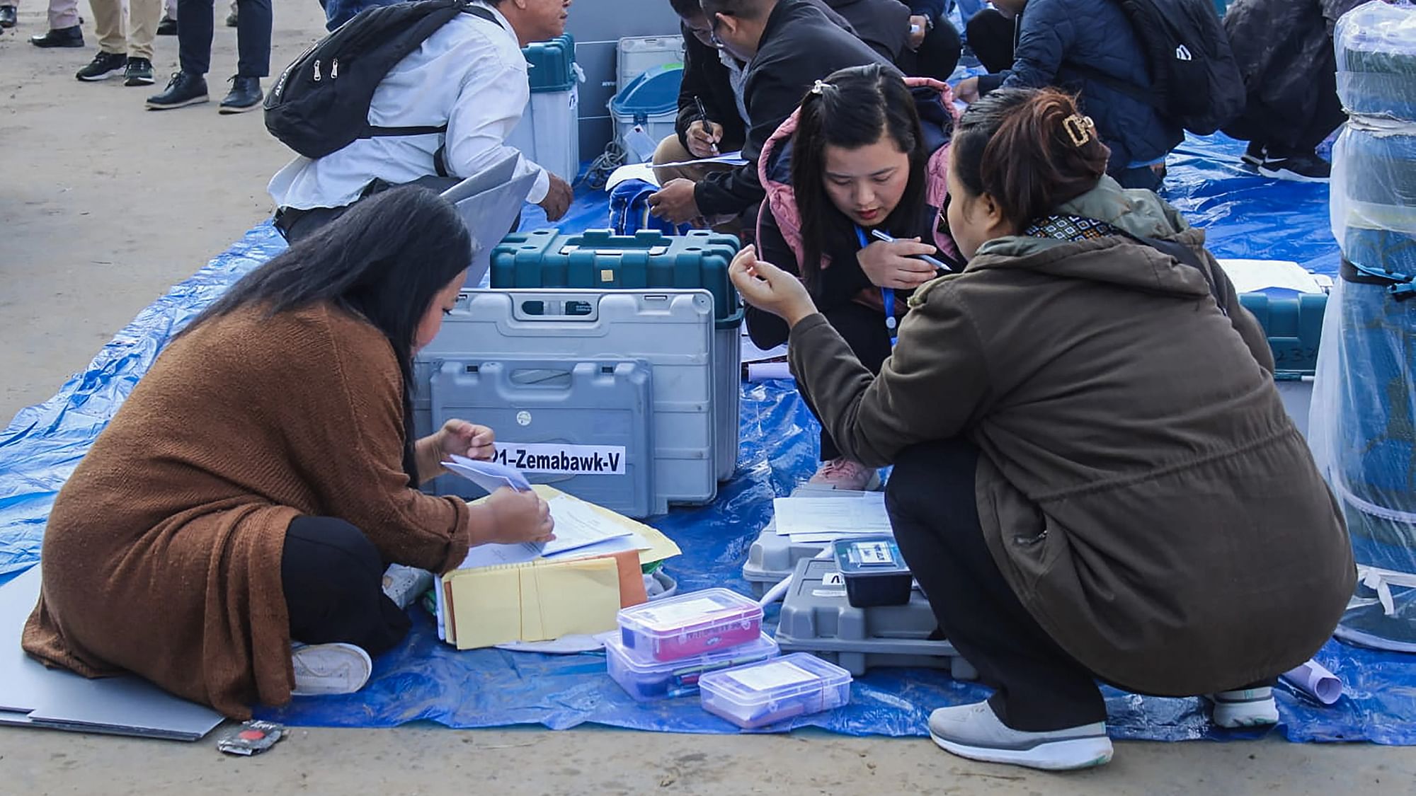 <div class="paragraphs"><p>Polling officials collect EVMs and other election material at a distribution centre ahead of voting for Mizoram Assembly elections.</p></div>