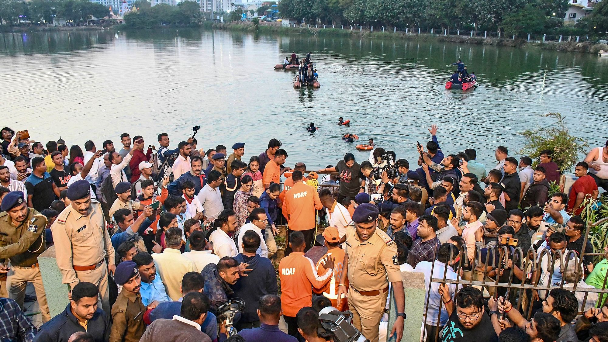 <div class="paragraphs"><p>People gather during a rescue and search operation after a boat overturned in a lake in Vadodara</p></div>