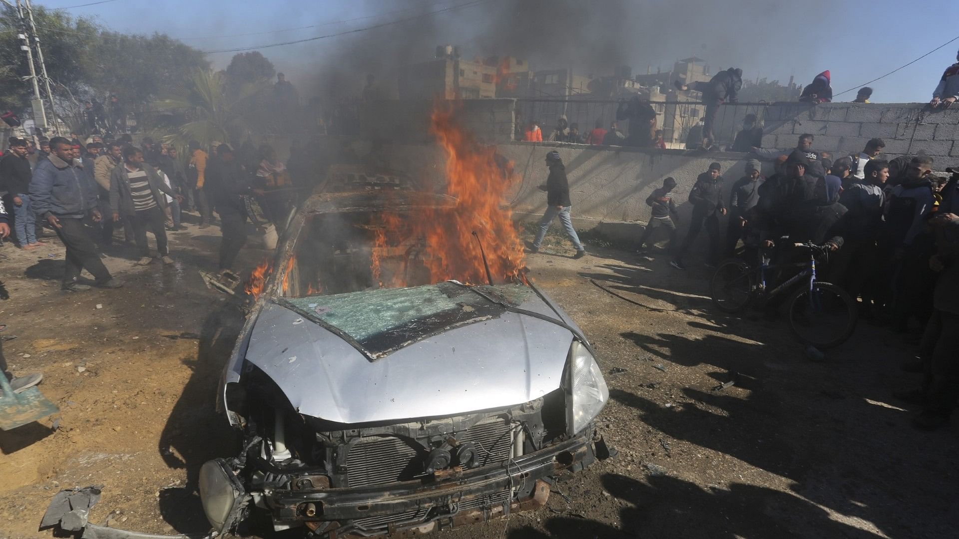 <div class="paragraphs"><p>Palestinians watch a car burn after it was hit by an Israeli in Rafah, Gaza Strip.&nbsp;</p></div>