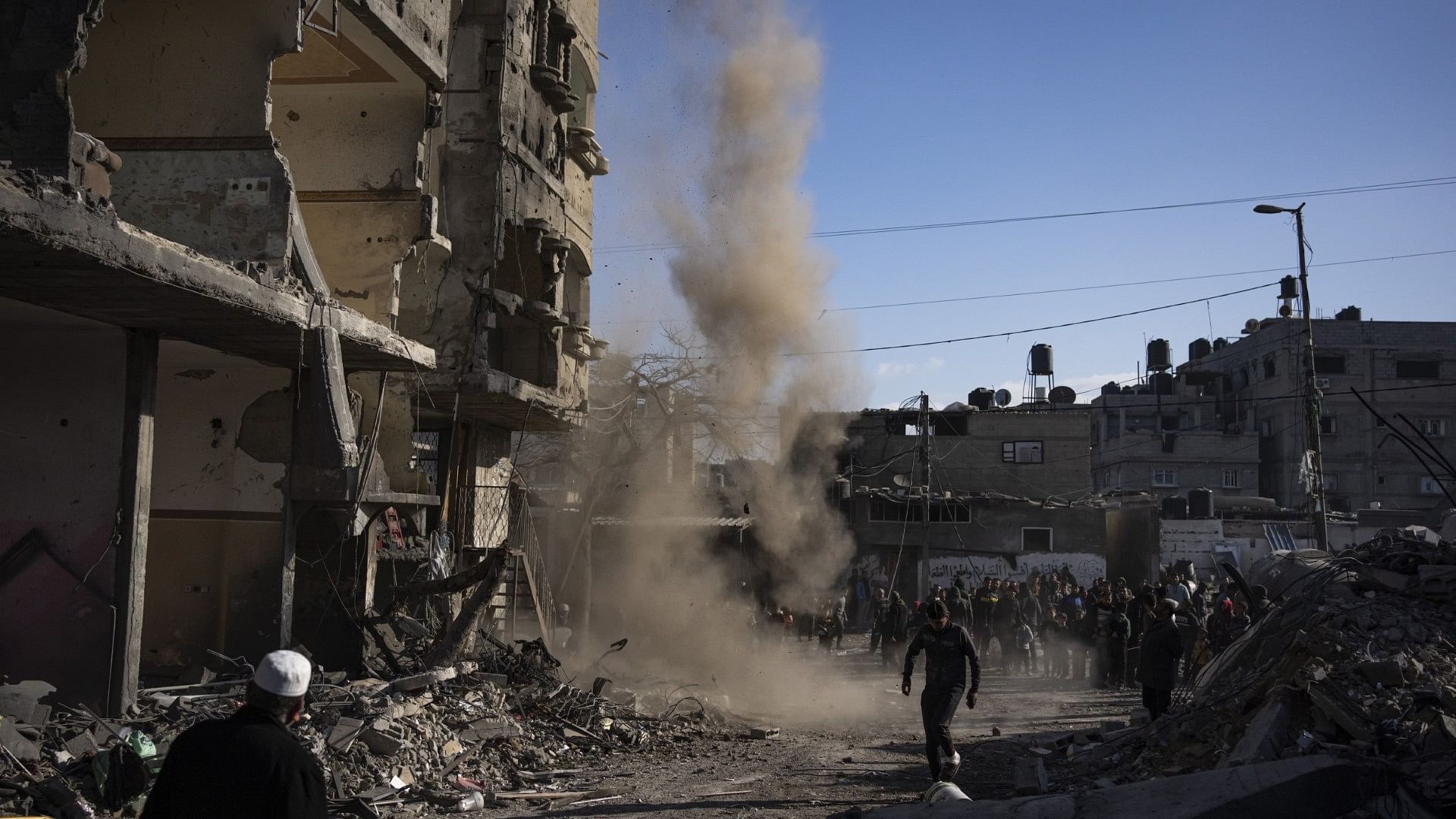 <div class="paragraphs"><p>Palestinians look at the destruction after an Israeli strike on residential buildings and a mosque in Rafah, Gaza Strip.</p></div>