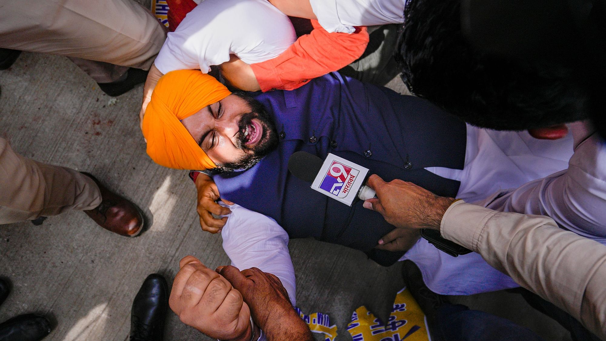 <div class="paragraphs"><p>Security personnel detain Punjab Minister and AAP leader Harjot Singh Bains during their protest outside Patel Chowk metro station against the arrest of Delhi CM Arvind Kejriwal, in New Delhi, on Tuesday, 26 March.</p></div>
