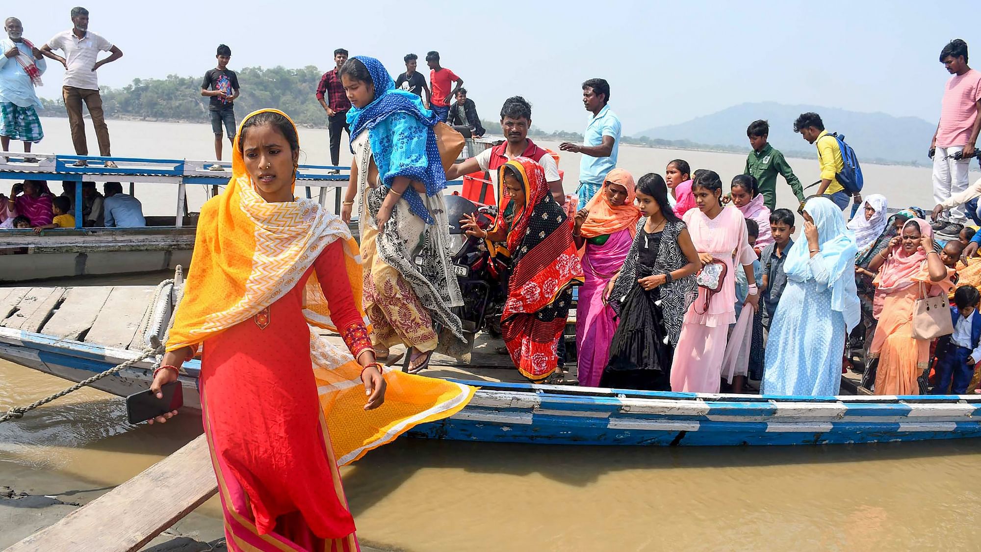 <div class="paragraphs"><p>Voters reach a polling station on a boat to cast their vote for the second phase of the Lok Sabha elections at Gashbari village, in Darrang district, Assam, on Friday, 26 April 2024.</p></div>