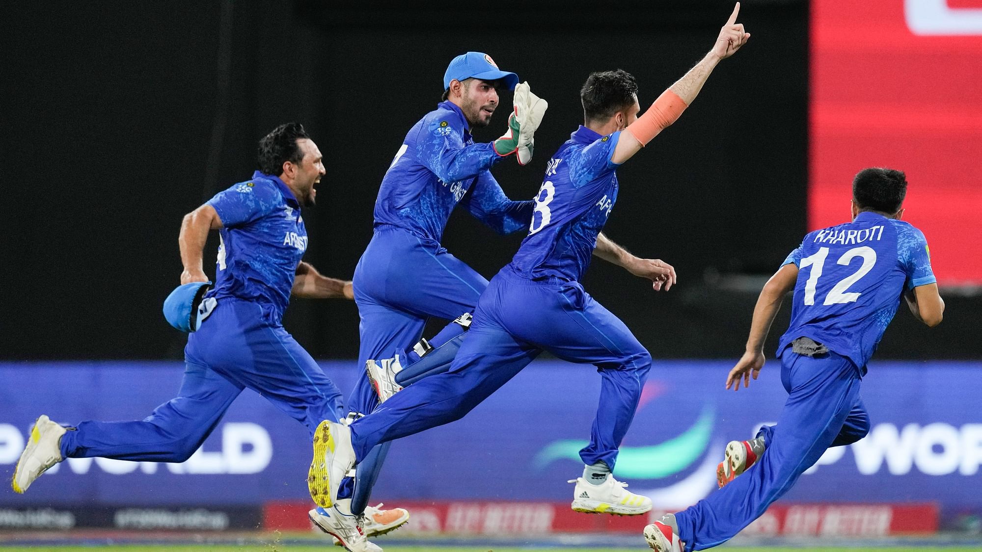 <div class="paragraphs"><p>Afghanistan's Ibrahim Zadran, centre, reacts with teammates after taking the wicket of Bangladesh's Mustafizur Rahman to win by eight runs in their men's T20 World Cup cricket match at Arnos Vale Ground, Kingstown, Saint Vincent and the Grenadines, Monday,</p></div>