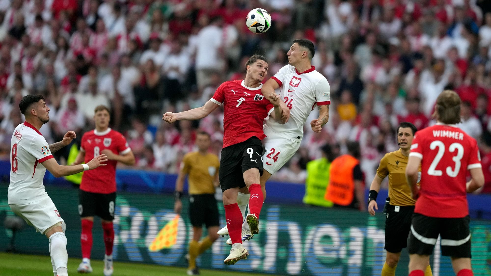 <div class="paragraphs"><p>Austria's Marcel Sabitzer (9) and. Poland's Bartosz Slisz (24) battle for a head ball during a Group D match between Poland and Austria at the Euro 2024 soccer tournament in Berlin, Germany, Friday, 21 June, 2024.</p></div>