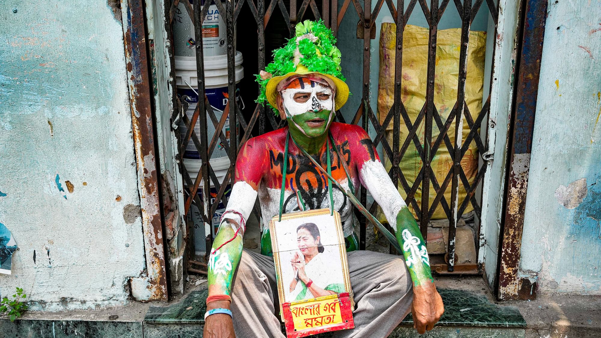 <div class="paragraphs"><p>Kolkata: A man with his body painted in colours of TMC flag waits near the residence of West Bengal Chief Minister Mamata Banerjee, at Kalighat in Kolkata, Tuesday, June 4, 2024.</p></div>