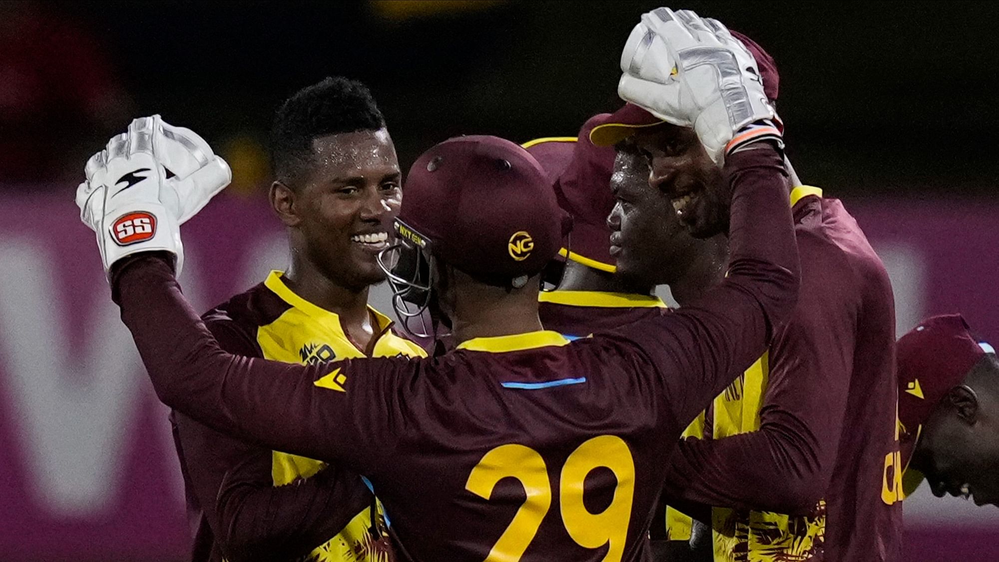 <div class="paragraphs"><p>West Indies Akeal Hosein, left, celebrates with teammates after their 134-run victory over Uganda during an ICC Men's T20 World Cup cricket match at Guyana National Stadium in Providence, Guyana, Saturday, 8 June, 2024.</p></div>