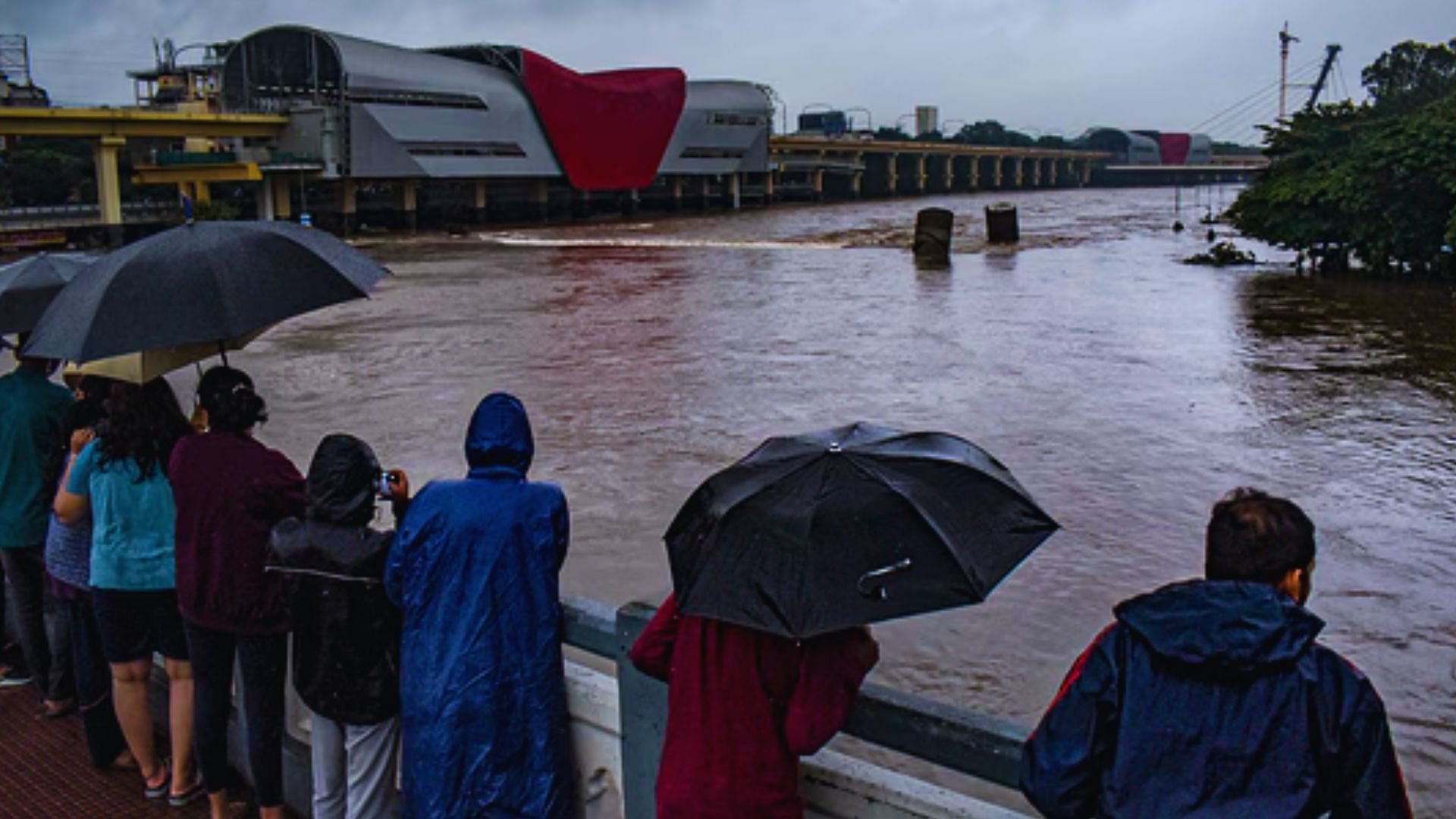 <div class="paragraphs"><p>Pune: People watch an overflowing Mutha river following heavy rainfall, in Pune district, Thursday, July 25, 2024. </p></div>