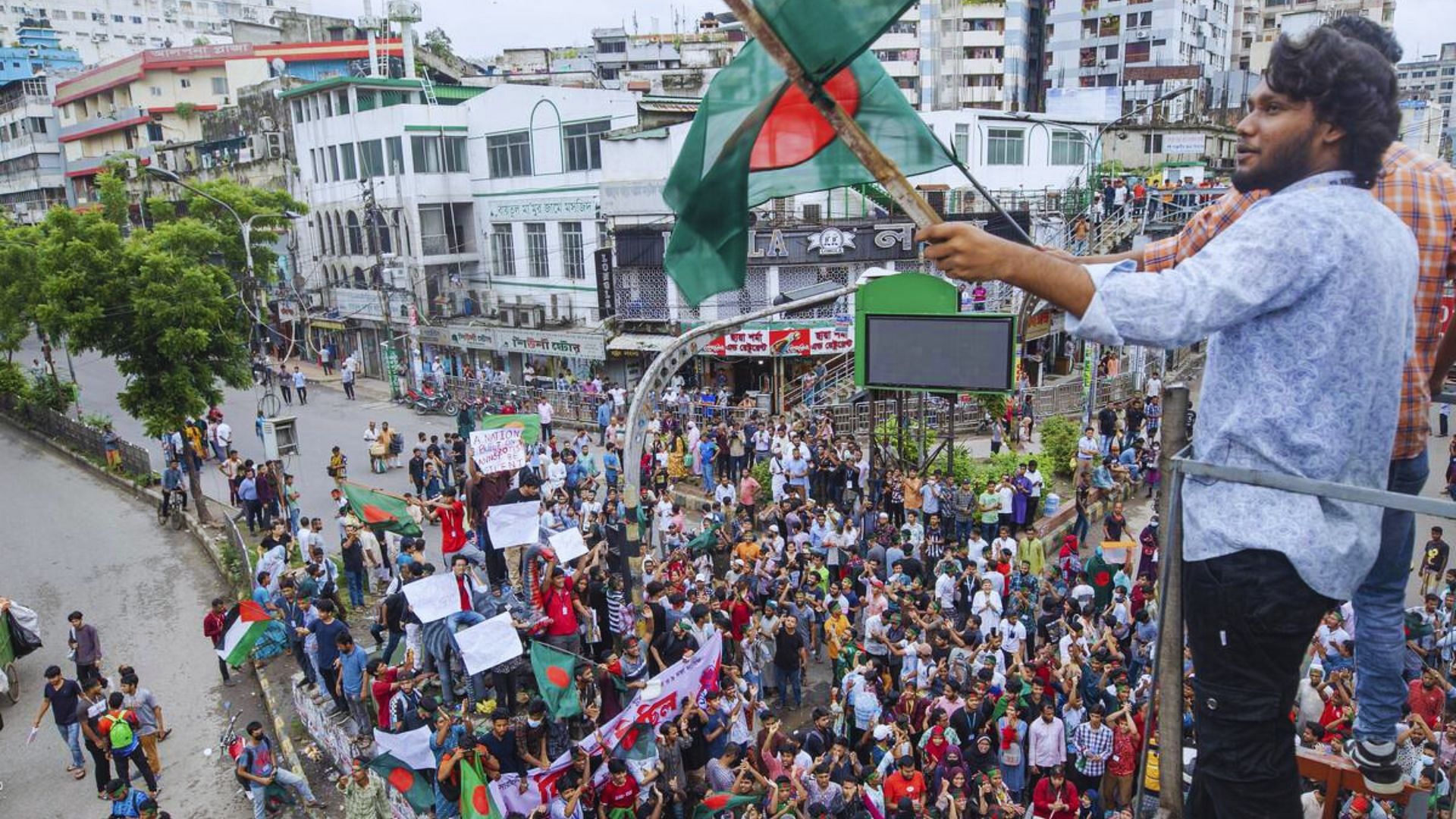 <div class="paragraphs"><p>An activist waves the Bangladesh flag during a protest march against Prime Minister Sheikh Hasina and her government to demand justice for the victims killed in the recent countrywide deadly clashes, in Dhaka, Bangladesh.</p></div>