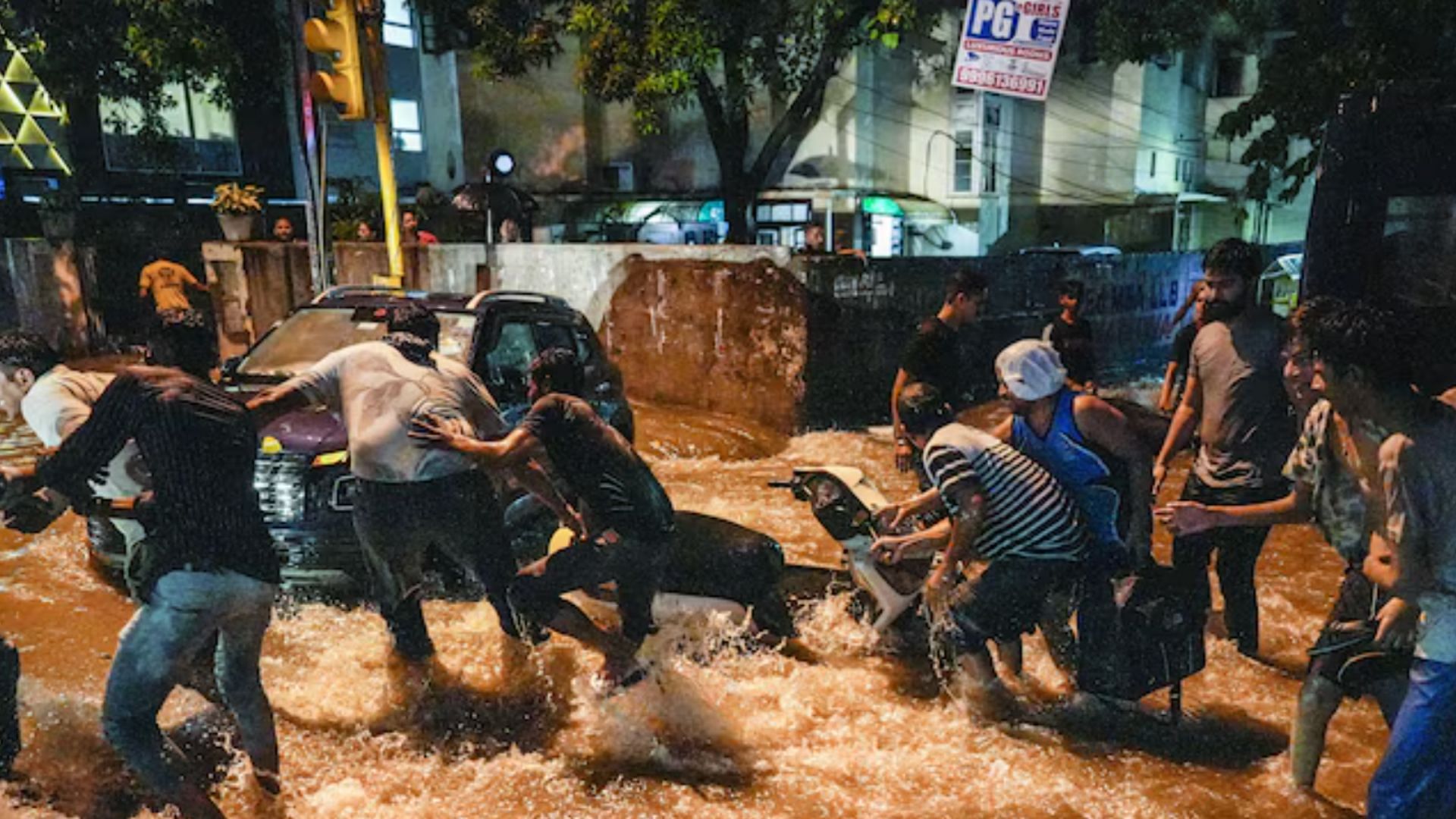 <div class="paragraphs"><p>People try to pull a two-wheeler from being swept away by rainwater near Old Rajinder Nagar during the rain in New Delhi on Wednesday (31 July).</p></div>