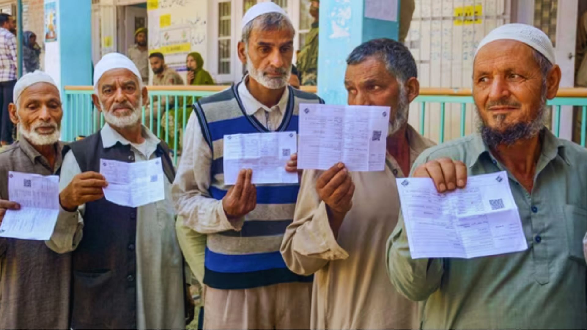 <div class="paragraphs"><p>Voters show their voting slips as they wait to cast votes at a polling station during the first phase of Jammu and Kashmir Assembly elections.</p></div>