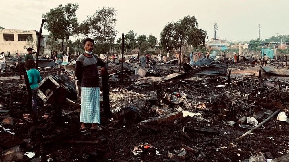 <div class="paragraphs"><p>A Rohingya man standing in front of a relief camp in Delhi that was burnt to ashes.</p></div>