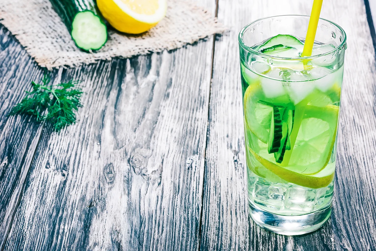 Elements like mint, cucumber and fruits are put in the pitcher full of water.