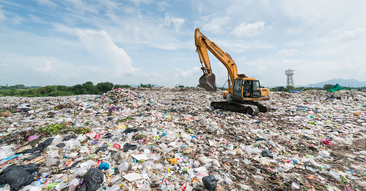A Backhoe car works in a sanitary landfill site.