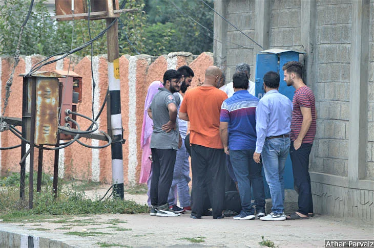 Locals huddle around technicians as they restore landlines in Haiderpura, Srinagar, 7 September, 2019.