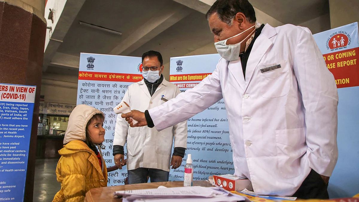 A doctor checks the temperature of a child passenger as part of precautionary measures against the new coronavirus, at a railway station in Jammu, Thursday, March 12, 2020.