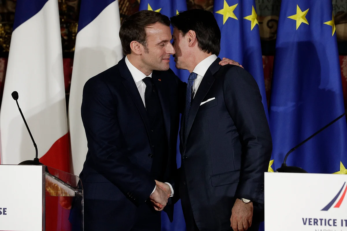 In this Thursday, Feb. 27, 2020 file photo, French President Emmanuel Macron, left, puts his arm around the shoulder of Italian Premier Giuseppe Conte and gives him a kiss on both cheeks during a joint press conference on the occasion of a French-Italian summit in Naples, southern Italy.
