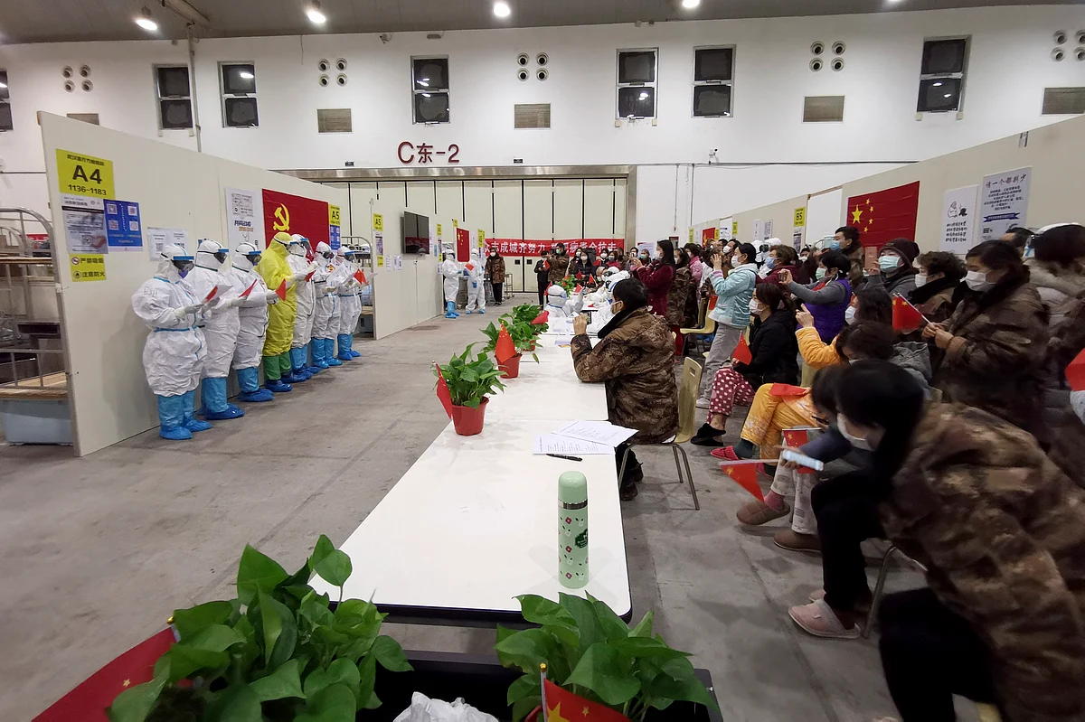 In this Feb. 28, 2020, photo released by Zhang Junjian, medical workers wearing protective suits in the Wuhan Living Room Temporary Hospital read poetry for patients in Wuhan in central China's Hubei province.