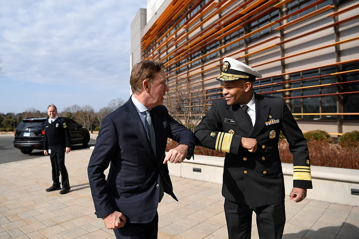 U.S. Surgeon General Vice Admiral Jerome M. Adams, right, bumps elbows with Connecticut Gov. Ned Lamont as they meet for a visit at the Connecticut State Public Health Laboratory, Monday, March 2, 2020, in Rocky Hill, Conn.