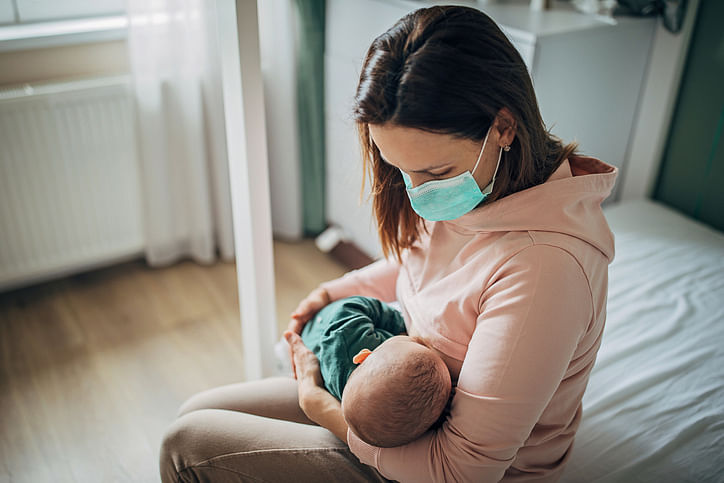 A COVID positive woman should put on a face mask and practice hand hygiene before breastfeeding.